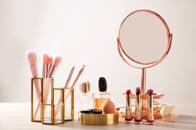 Set of makeup products and brushes on table