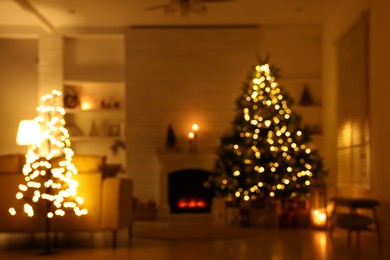 Blurred view of festively decorated living room with Christmas tree near fireplace