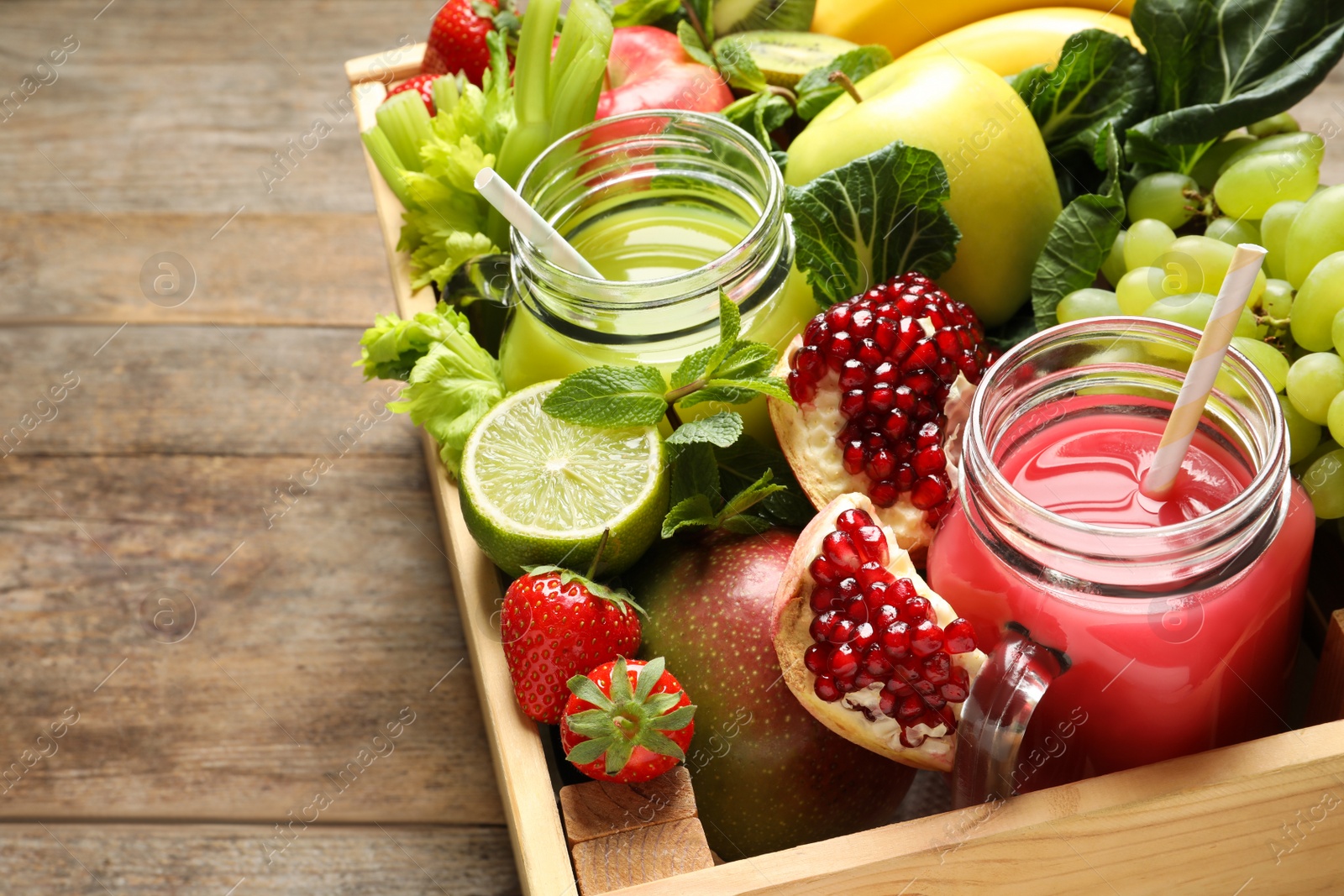 Photo of Wooden crate with juices in mason jars and fresh fruits on wooden background. Space for text