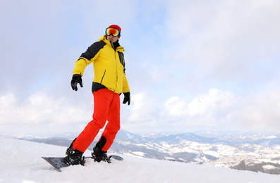 Photo of Male snowboarder on snowy hill. Winter vacation