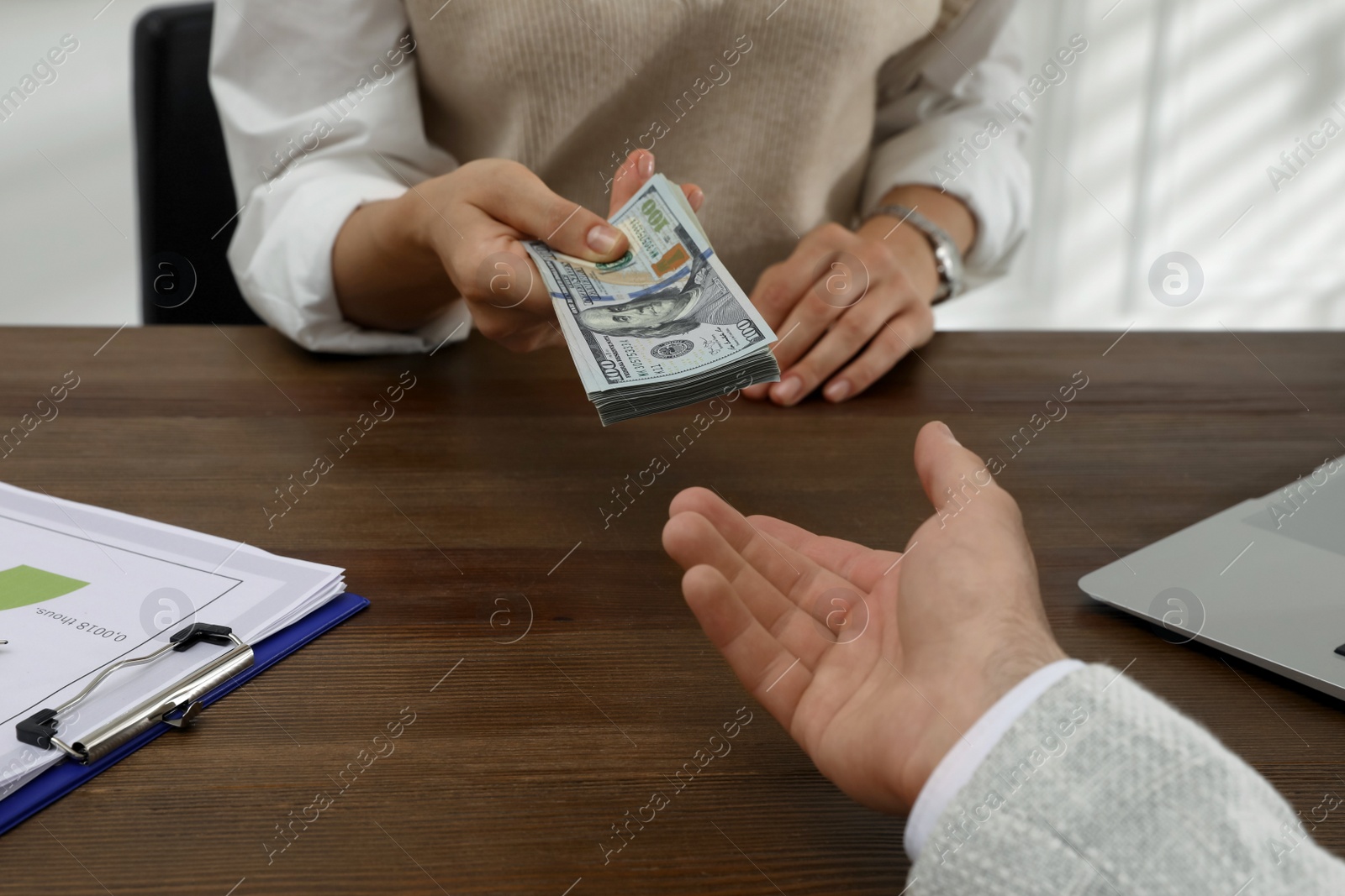 Photo of Cashier giving money to businessman at desk in bank, closeup