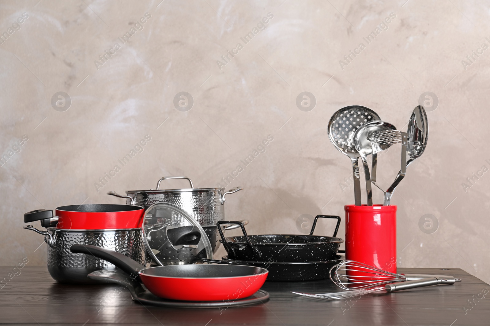 Photo of Set of clean cookware and utensils on table against color background, space for text