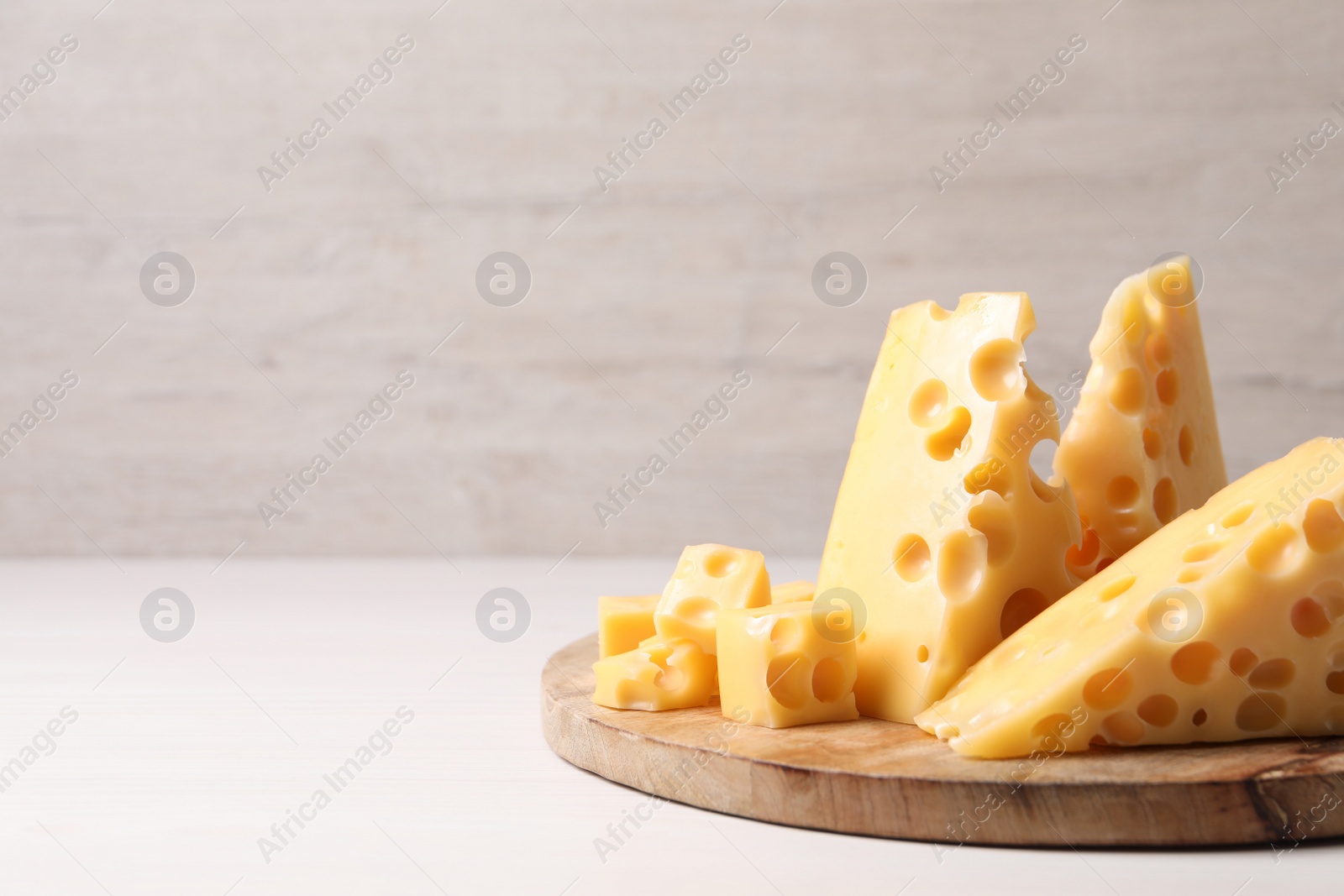 Photo of Tasty fresh cheese on white wooden table, closeup. Space for text