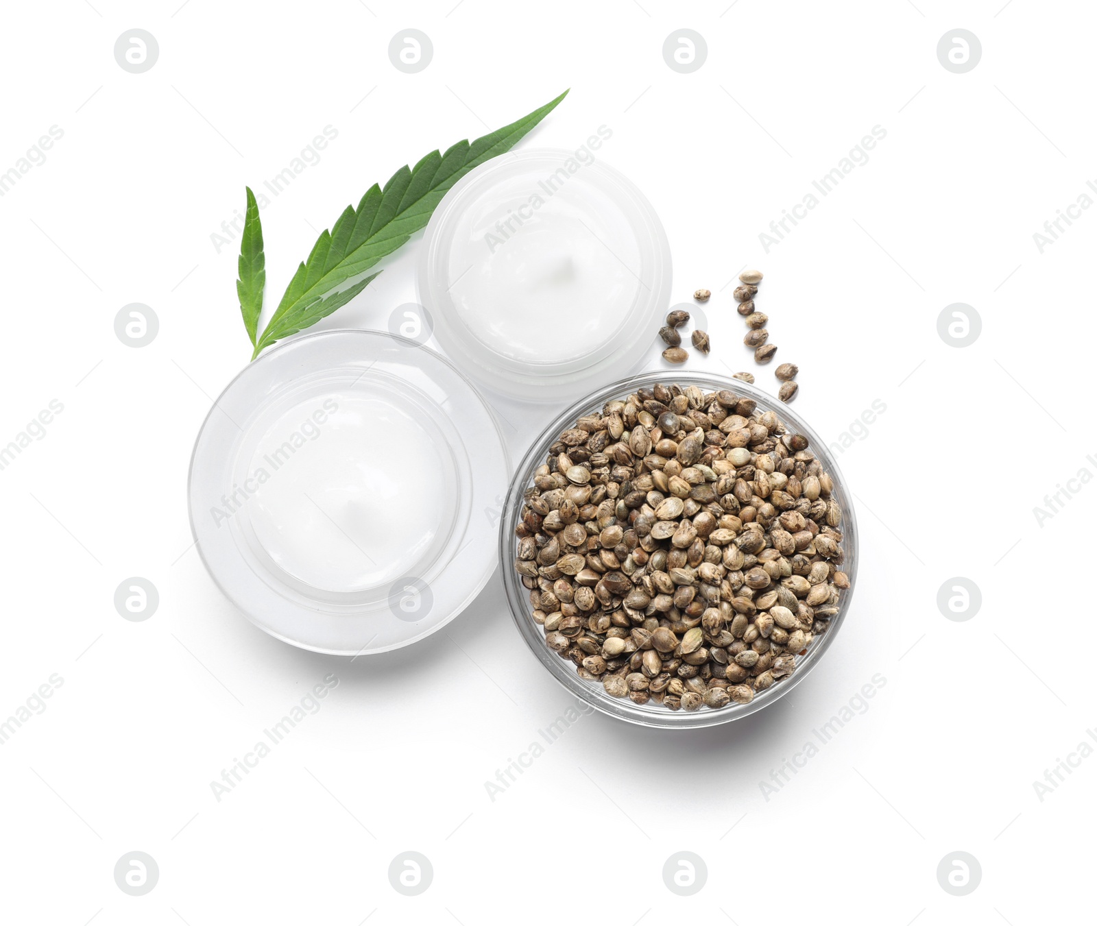 Photo of Jars with hemp cream, seeds and green leaf on white background, top view. Natural cosmetics