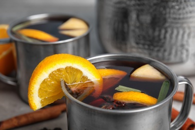 Tasty mulled wine with spices on table, closeup