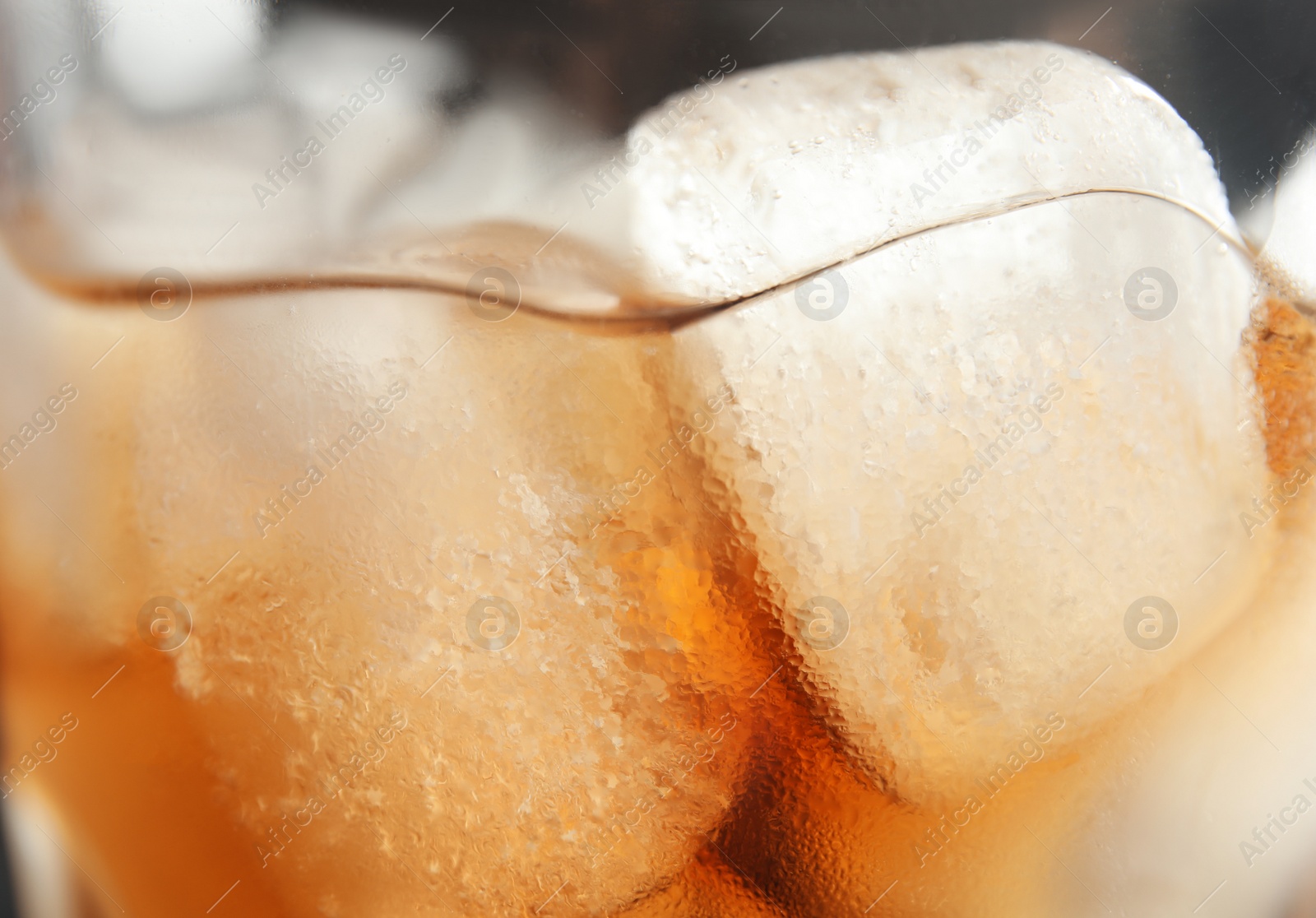 Photo of Glass of tasty refreshing cola with ice cubes, closeup