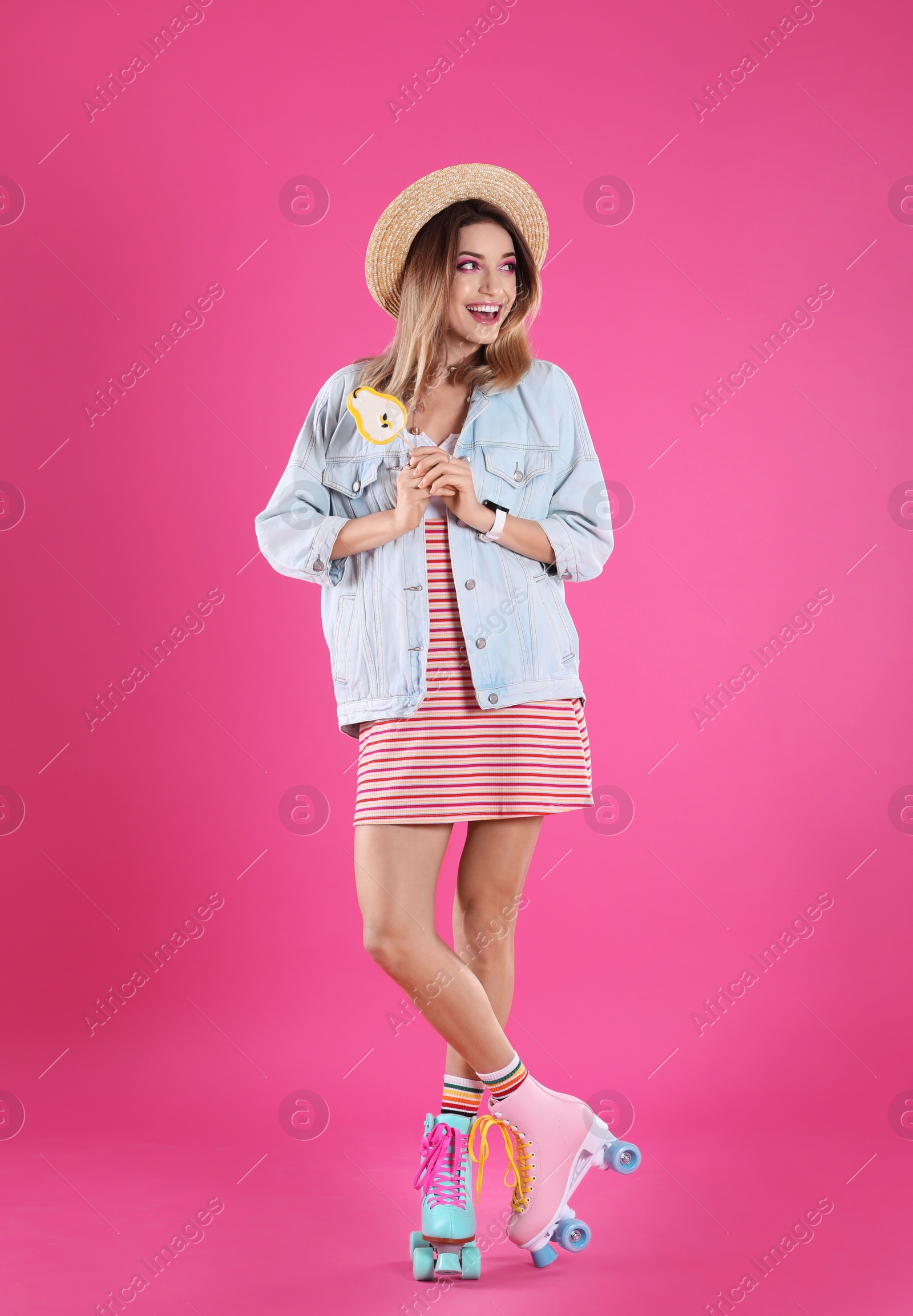 Photo of Young woman with lollipop and retro roller skates on color background