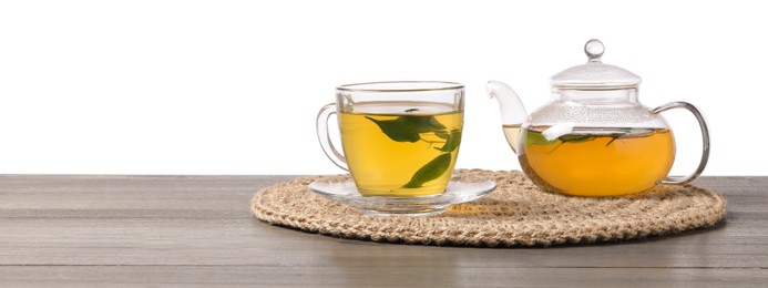 Photo of Refreshing green tea in cup and teapot on grey wooden table against white background