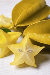 Photo of Delicious carambola fruits on white wooden table