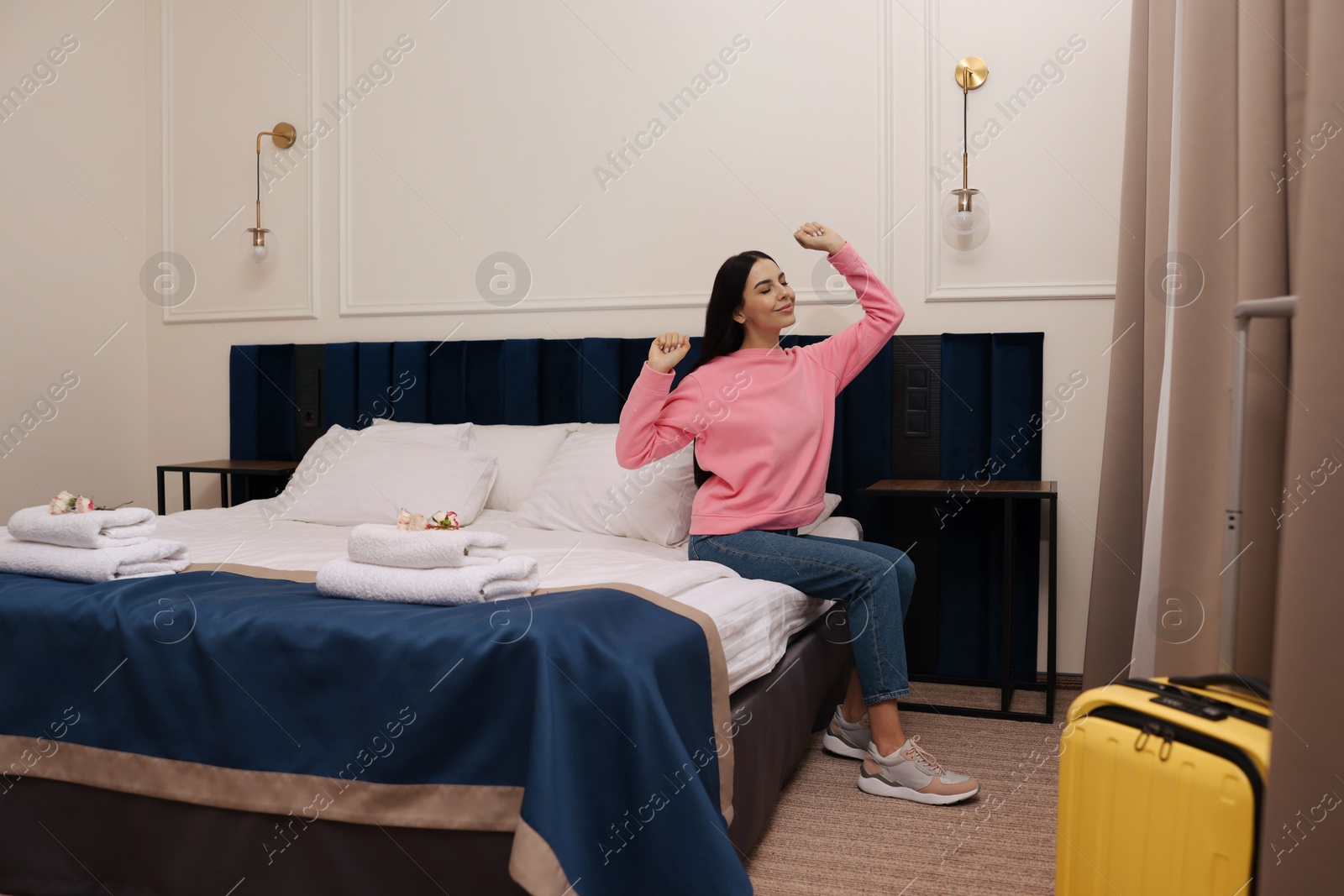 Photo of Beautiful young woman relaxing on bed in hotel room