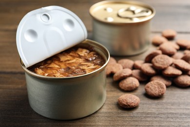 Photo of Wet and dry pet food on wooden table, closeup