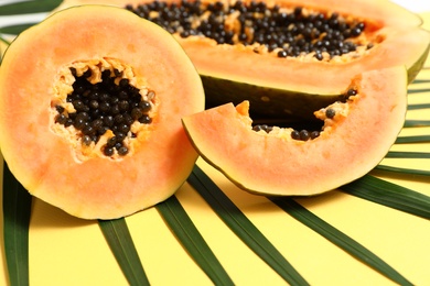 Fresh juicy cut papaya on yellow background, closeup view