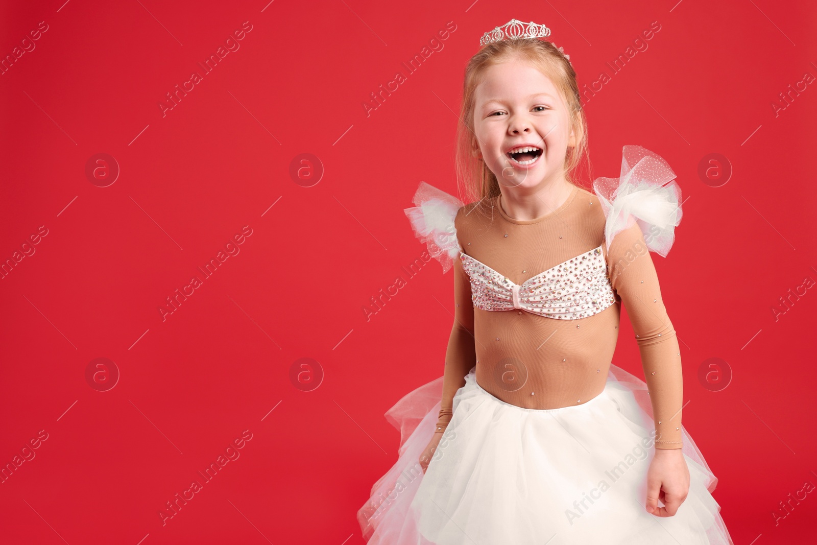 Photo of Cute girl in fairy dress with diadem on red background, space for text. Little princess