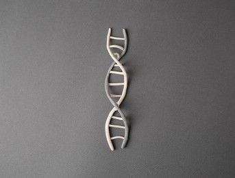 Photo of DNA molecule model made of grey plasticine on black background, top view