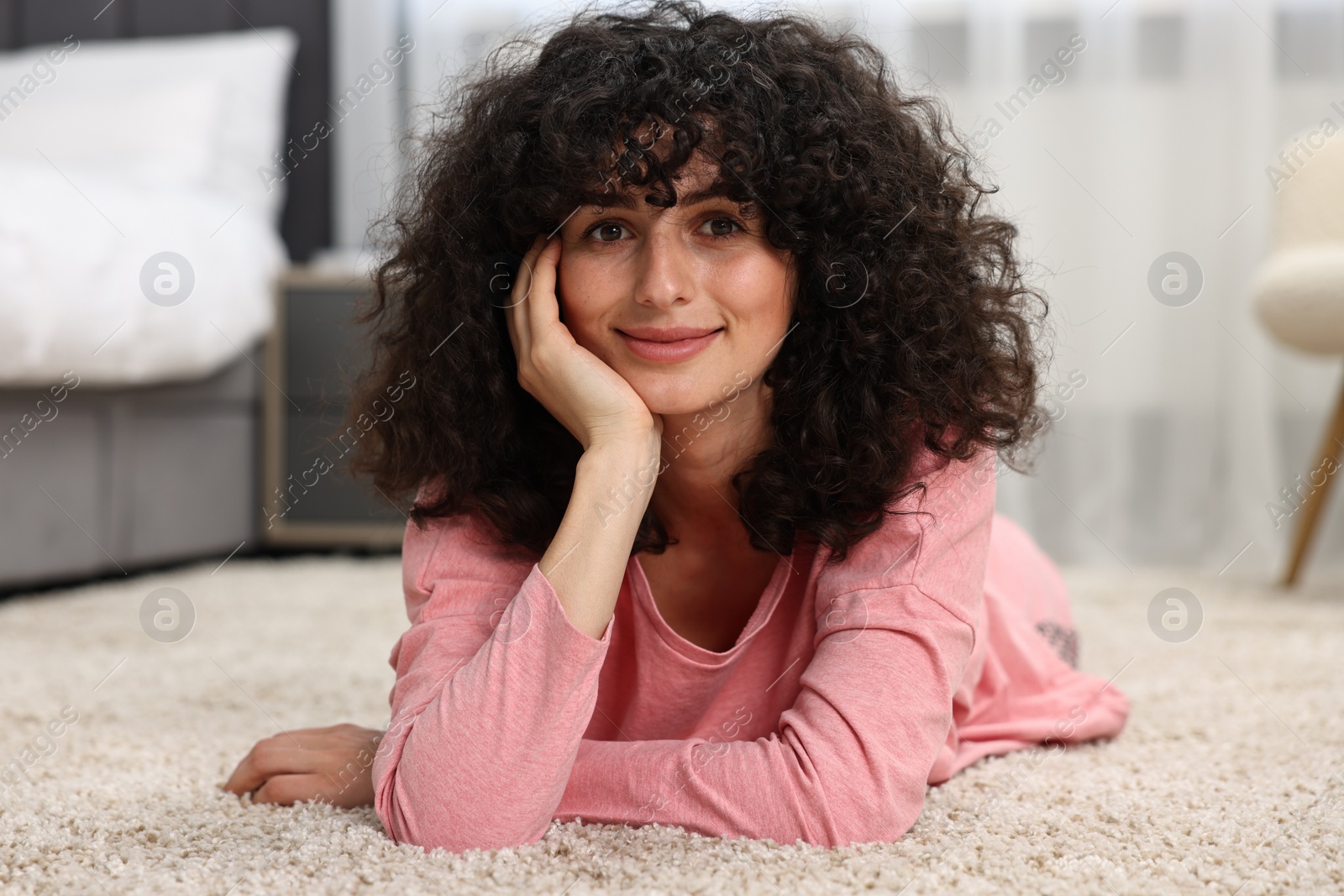 Photo of Beautiful young woman in stylish pyjama on floor at home