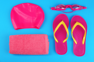 Photo of Flat lay composition with swimming accessories on light blue background