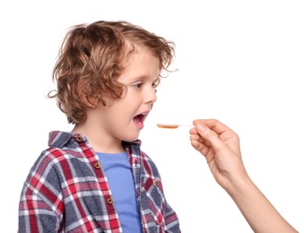 Photo of Mother giving cough syrup to her son against white background, closeup