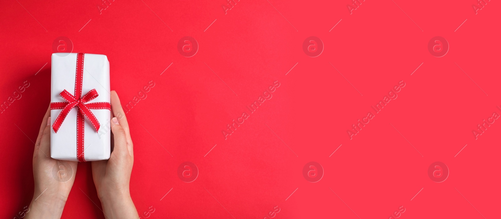 Image of Woman with gift box and space for text on red background, top view. Banner design