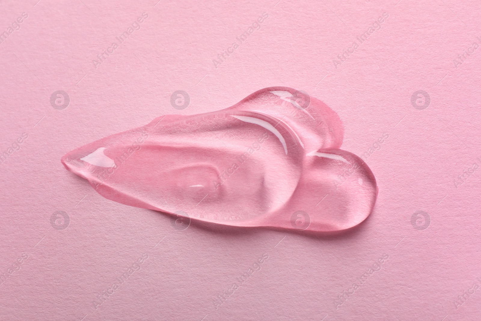 Photo of Swatches of cosmetic gel on pink background, top view