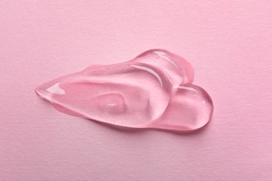 Photo of Swatches of cosmetic gel on pink background, top view