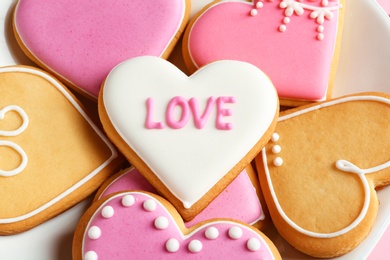 Photo of Decorated heart shaped cookies on plate, closeup. Valentine's day treat