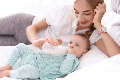 Woman feeding her child in bedroom. Healthy baby food