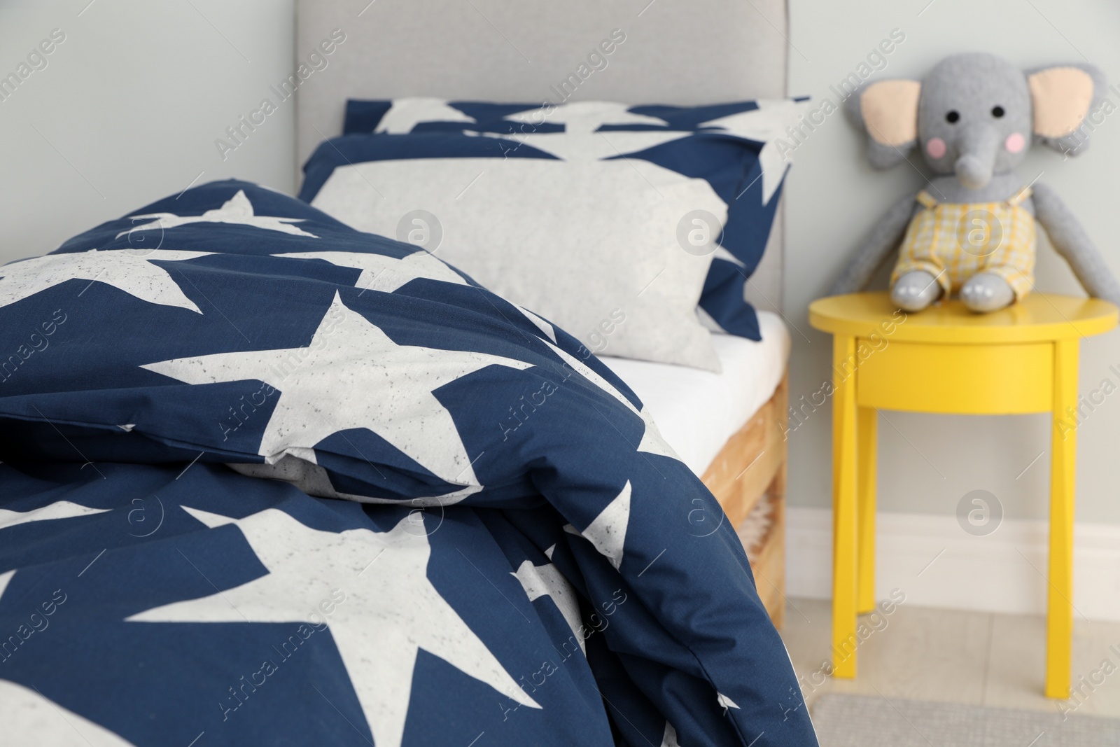 Photo of Bed with star patterned linens in child's bedroom. Interior design