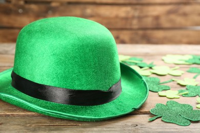 Photo of Leprechaun's hat and decorative clover leaves on wooden background. St. Patrick's day celebration