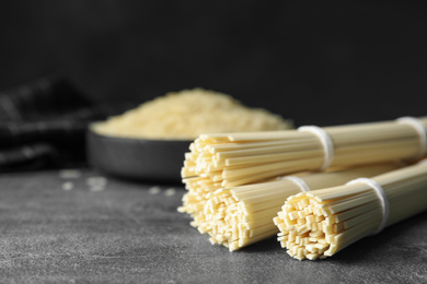 Raw rice noodles on grey table, closeup. Space for text