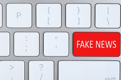 Image of Modern computer keyboard with text FAKE NEWS on button, top view