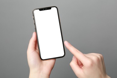 Photo of Woman using smartphone on grey background, closeup. Mockup for design