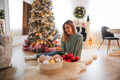 Photo of Beautiful woman decorating Christmas tree at home