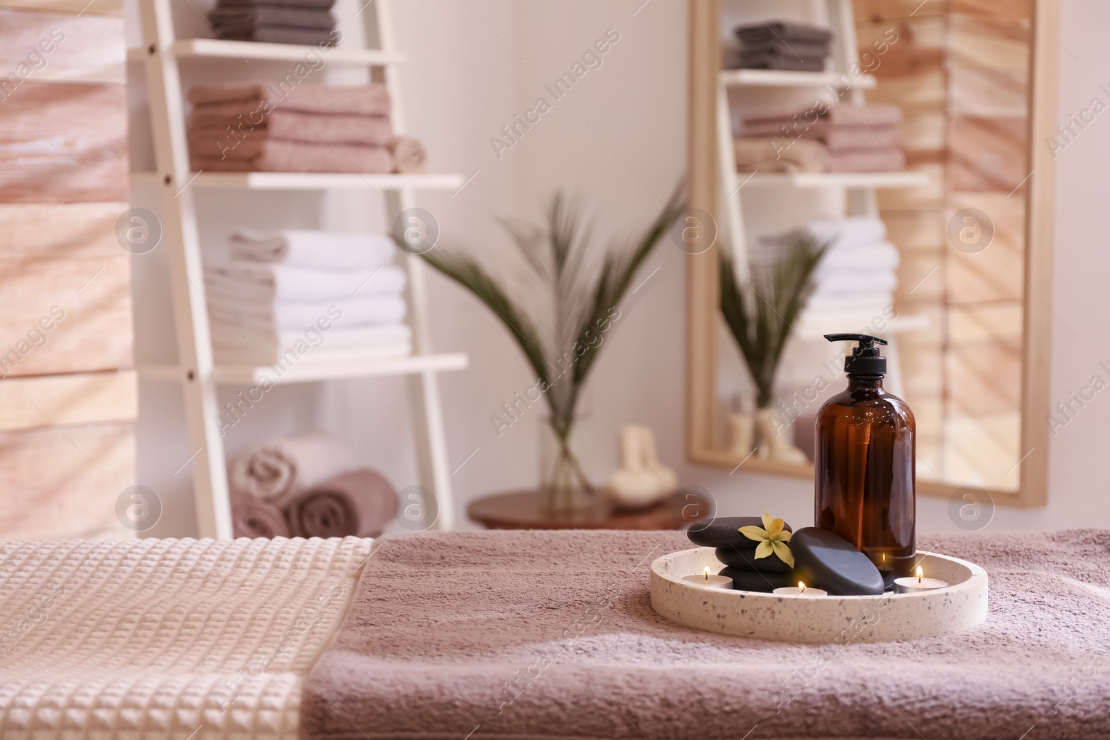 Photo of Beautiful spa accessories on massage table in room