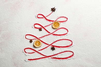 Photo of Christmas tree made of flour, orange and anise on red background, flat lay