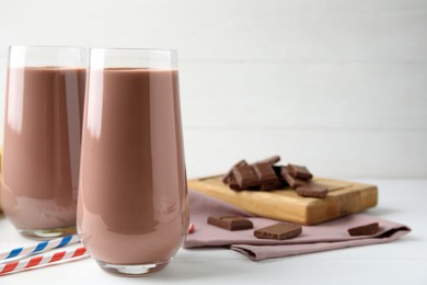 Photo of Fresh yummy chocolate milk on white wooden table. Space for text