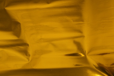 Photo of Plain golden surface as background, closeup view