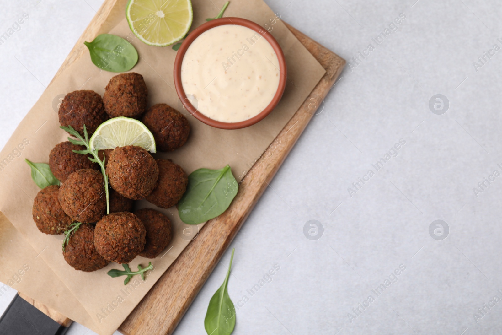 Photo of Delicious falafel balls served on light table, top view. Space for text