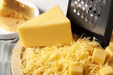 Photo of Grated and whole pieces of cheese on table, closeup