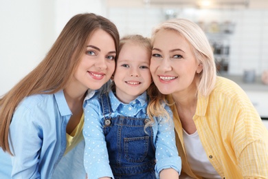 Photo of Portrait of young woman, her mature mother and daughter indoors