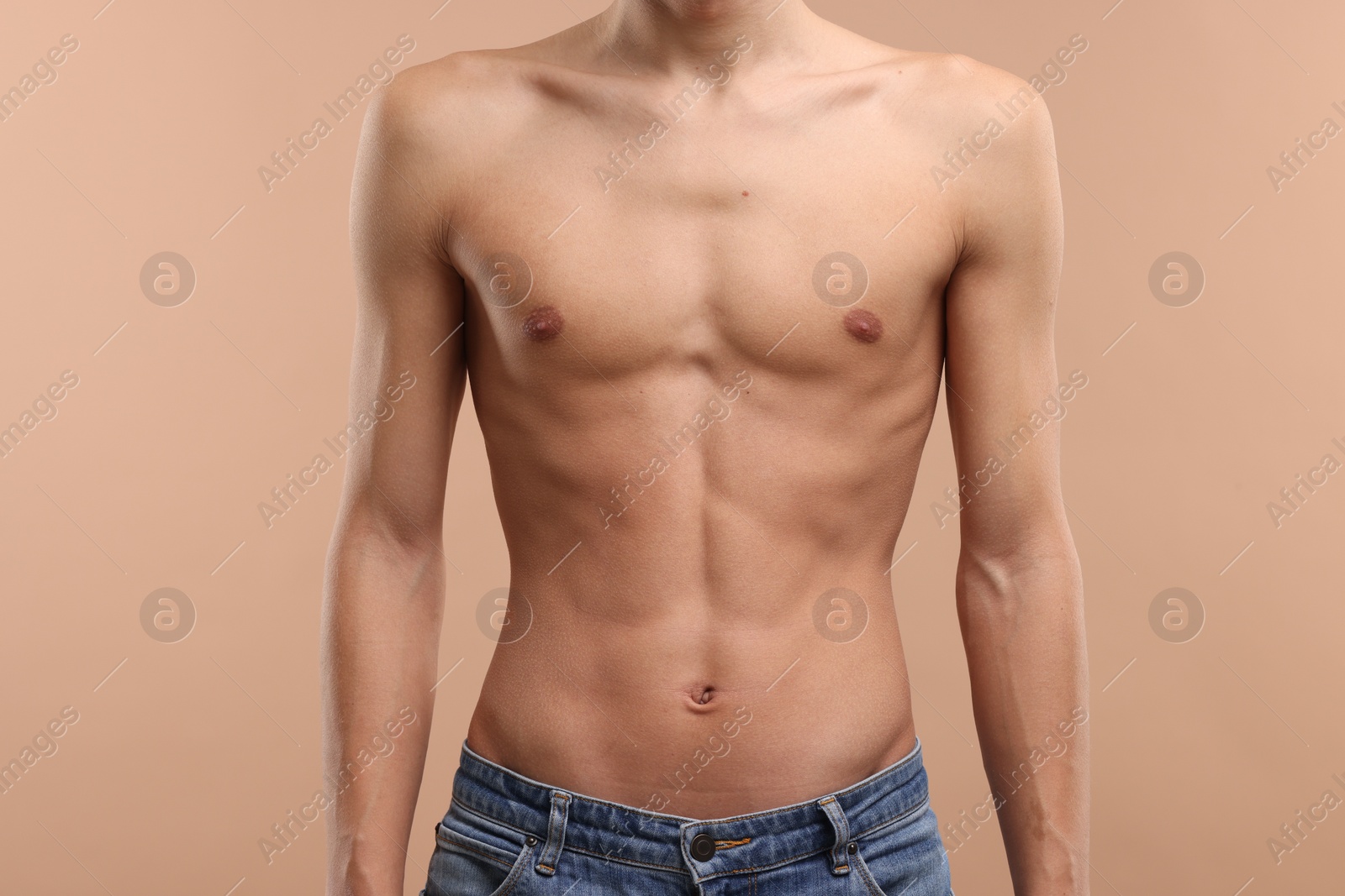 Photo of Shirtless man with slim body on beige background, closeup