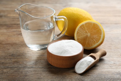 Photo of Composition with baking soda and cut lemons on wooden table