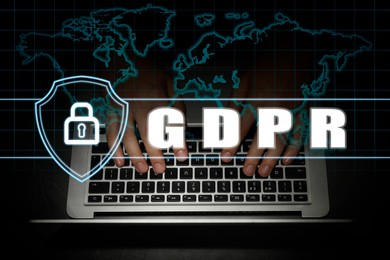 Image of General Data Protection Regulation. Man working with laptop on black background, closeup. GDPR abbreviation, shield with padlock and world map