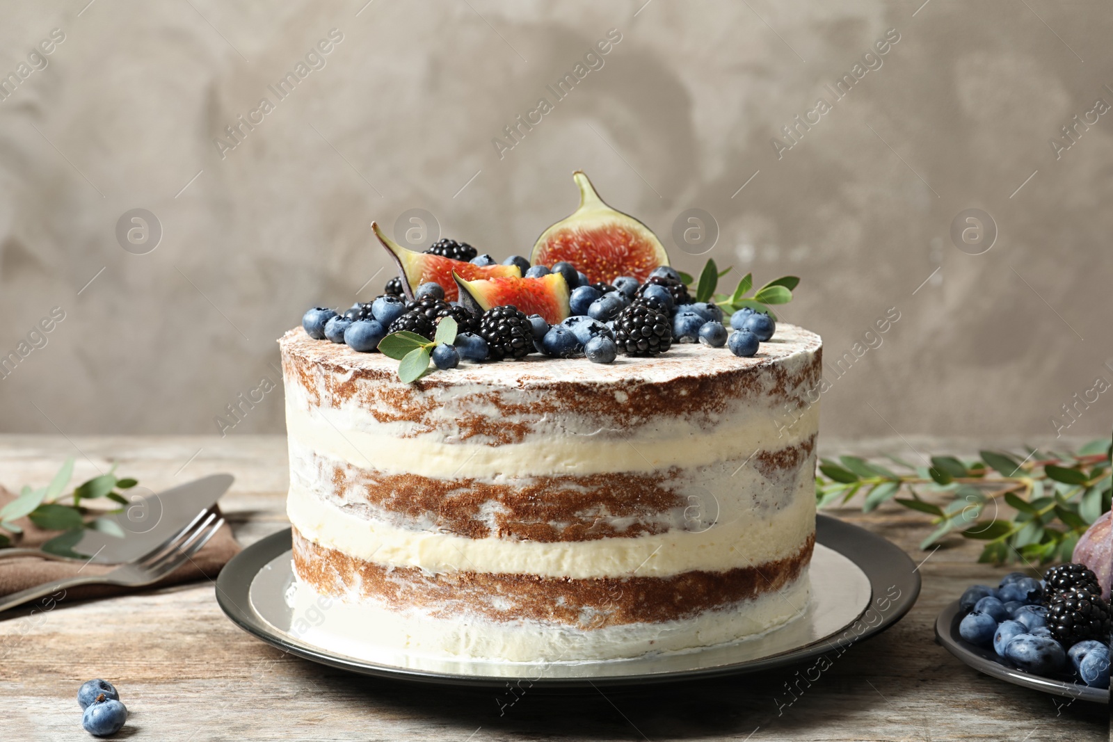 Photo of Delicious homemade cake with fresh berries served on wooden table