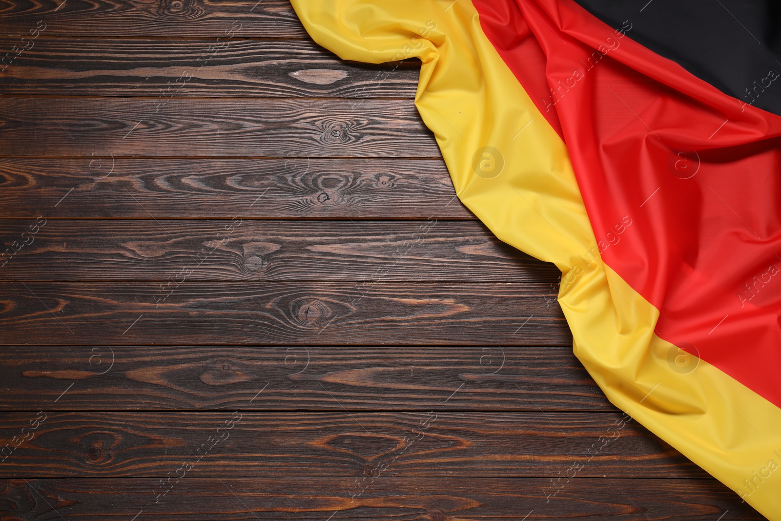 Photo of Flag of Germany on dark wooden background, top view. Space for text