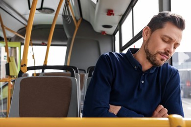 Photo of Tired man sleeping while sitting in public transport