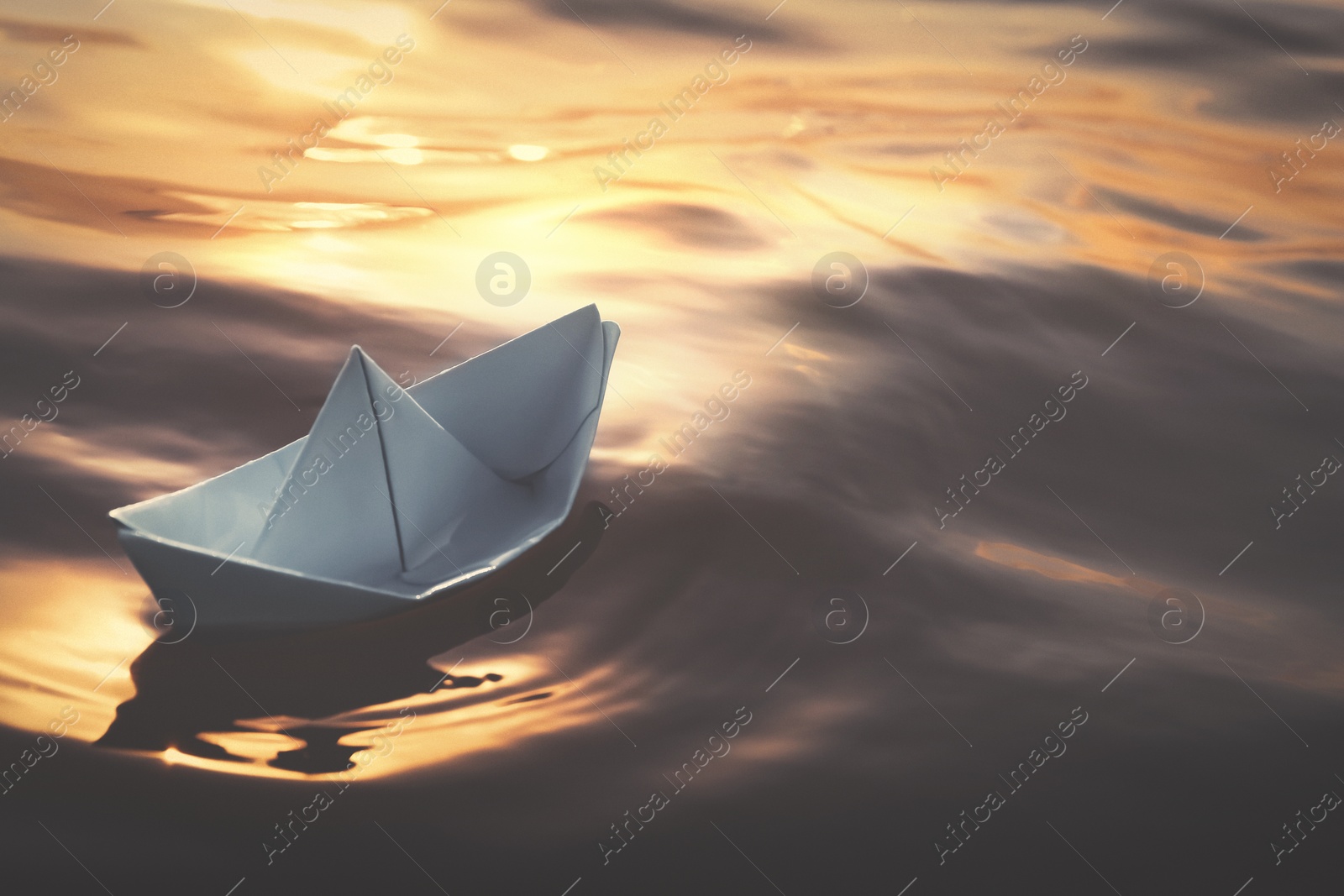 Image of White paper boat floating on river. Retro photo effect