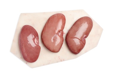 Photo of Board with fresh raw pork kidneys on white background, top view
