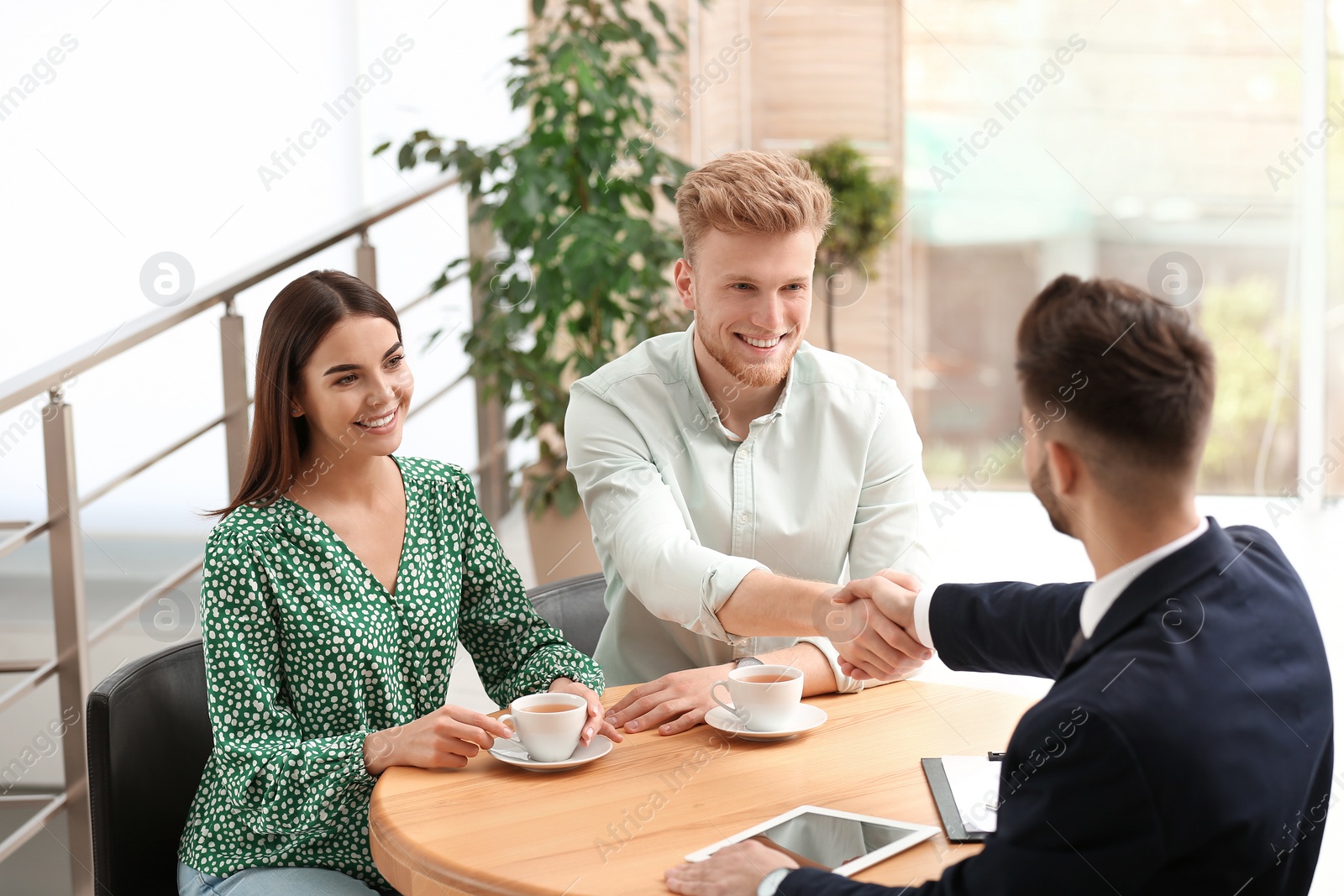 Photo of Insurance agent shaking hands with client in office