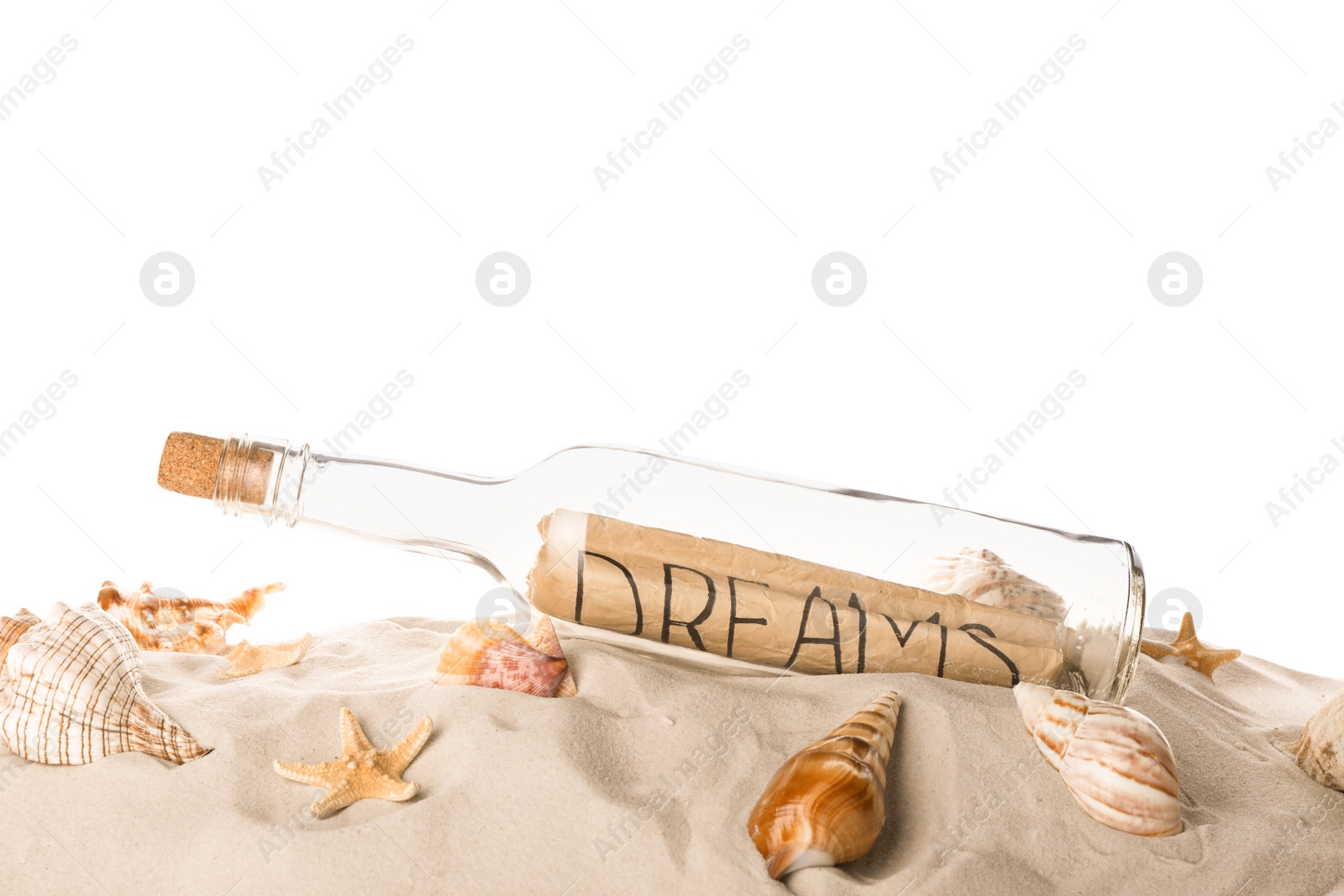 Photo of Corked glass bottle with Dreams note and seashells on sand against white background
