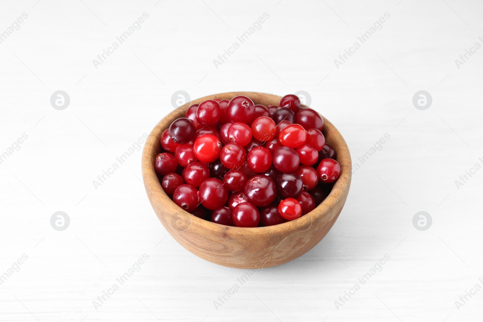 Photo of Fresh ripe cranberries in bowl on white table